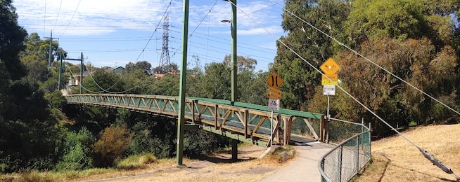 Picture of the current Harding Street Bridge was has wooden railings, the top rail painted green.